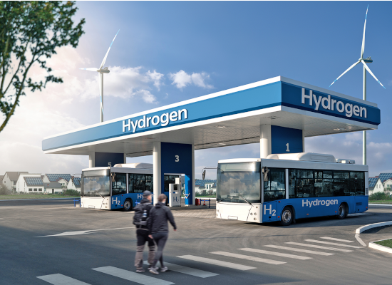  Two people walking towards a hydrogen station with two parked buses. 