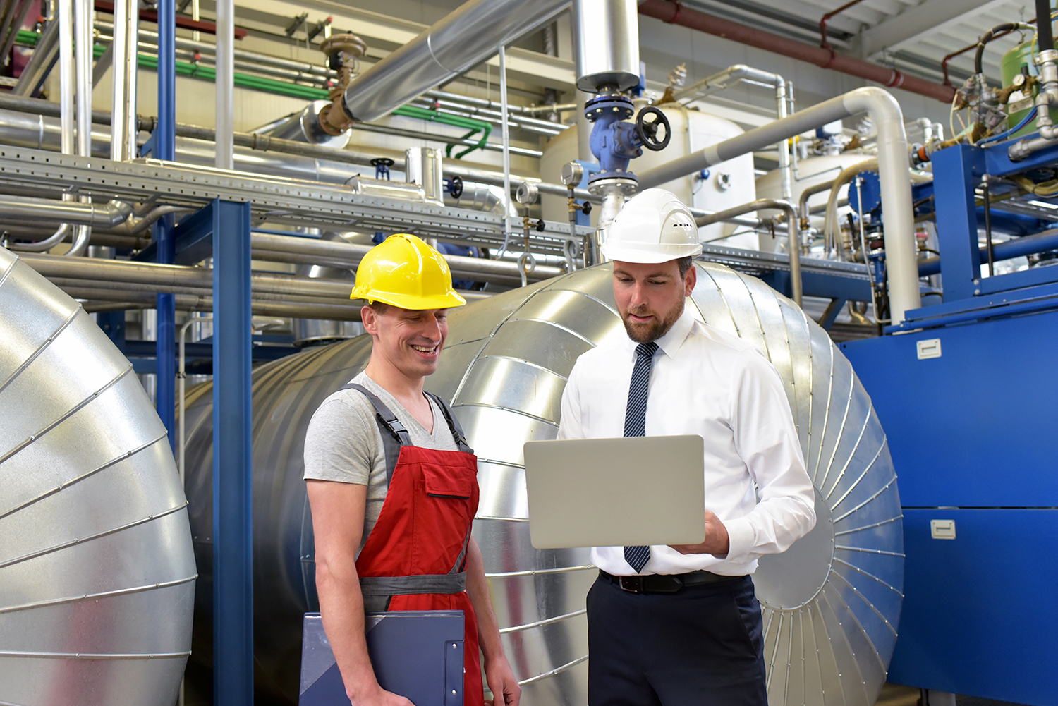 businessman and worker meeting in a factory - maintenance and repair of the industrial plant 