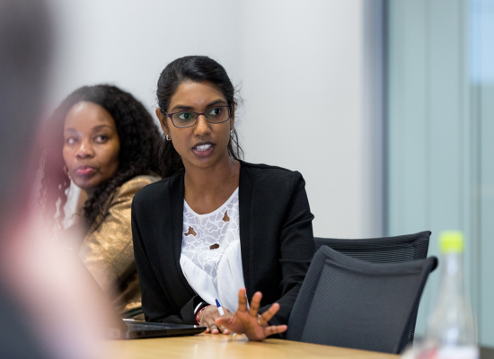 a woman sitting at a table in a discussion