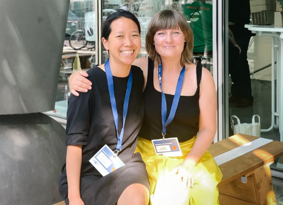 two women arm in arm smiling at the camera