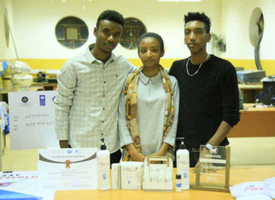 two men and one women standing in front of products
