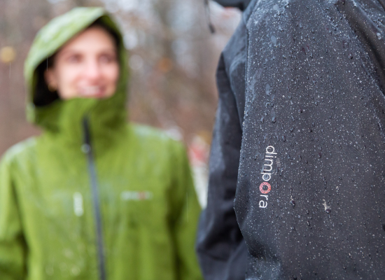 Two people talking; faces are blured, focus on the jackets, that seem to repell raindrops