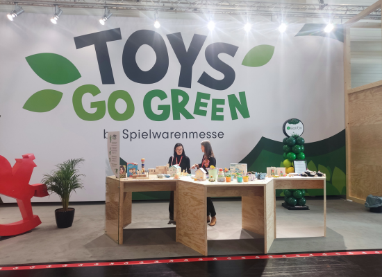 two women standing at the "Toys go green" booth