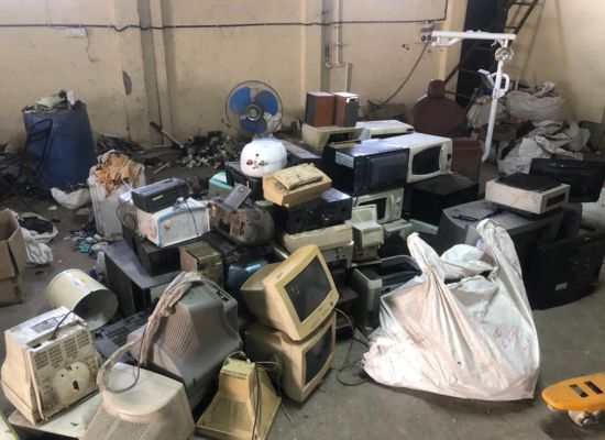 A pile of electronic waste in a storage room.